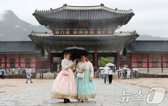 비가 내리는 12일 오후 한복을 입고 서울 종로구 경복궁을 찾은 외국인 관광객이 우산을 쓰고 이동하고 있다. 2024.9.12/뉴스1 ⓒ News1 박세연 기자