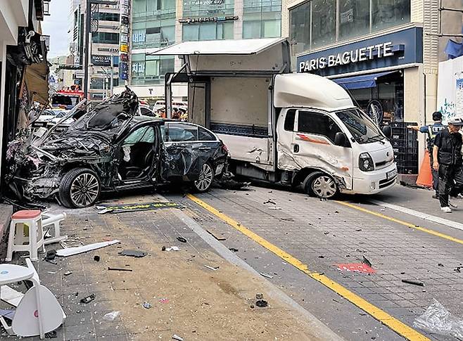 2일 오후 부산 해운대구에서 벤츠 승용차가 인도로 돌진해 정차해 있던 1t 트럭과 가게를 들이받고 멈춰 선 모습. 이 과정에서 행인 2명이 차에 치여 숨졌다. 사고 현장은 편도 1차로인 일방통행로로 가드레일이 설치돼 있지 않았다. /부산소방재난본부