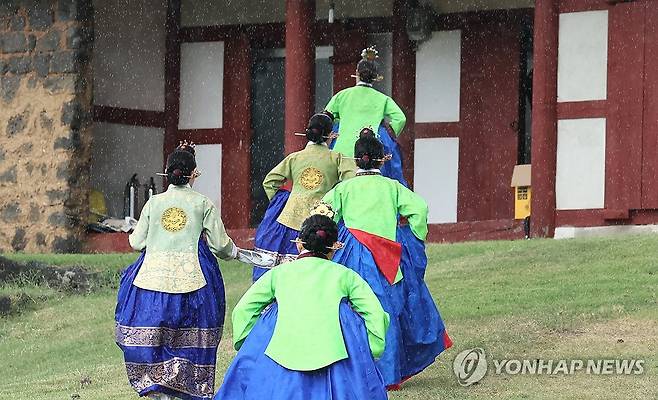 소나기에 급해진 발걸음 (제주=연합뉴스) 박지호 기자 = 10일 오전 제주시 용담1동 제주향교에서 봉행된 추기 석전대제 도중 소나기가 내리자 태평무 공연단이 비를 피하고 있다.
    추기 석전대제는 매년 음력 8월 공자를 비롯한 성현들의 학덕을 추모하는 제사다. 2024.9.10 jihopark@yna.co.kr