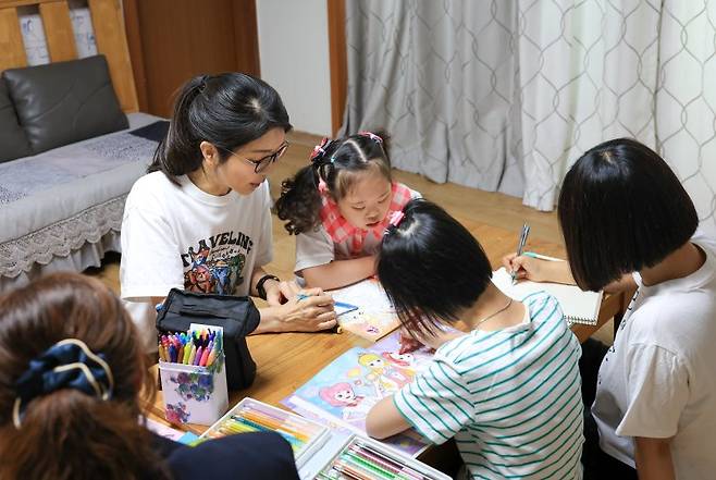 윤석열 대통령 부인 김건희 여사가 추석 명절 연휴인 15일 서울 은평구 다움장애아동지원센터를 찾아 어린이들의 밑그림을 도와주고 있다. (사진=대통령실 제공) /사진=뉴시스화상