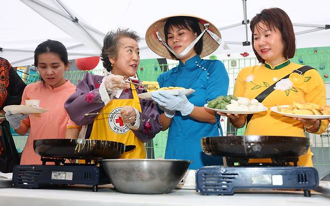 서울 양천구 대한적십자사 서울지부 서부봉사관에서 열린 ‘다같이학교 한가위축제’ 행사에서 다문화가구 구성원들이 한국 추석음식을 만들고 있다. [사진 출처 = 연합뉴스]