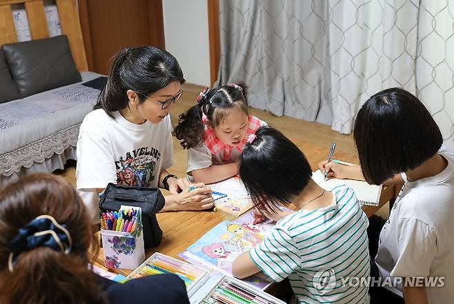 김건희 여사가 추석 명절 연휴인 15일 서울 은평구 다움장애아동지원센터를 방문해 어린이들의 밑그림을 도와주고 있다. 대통령실 제공.