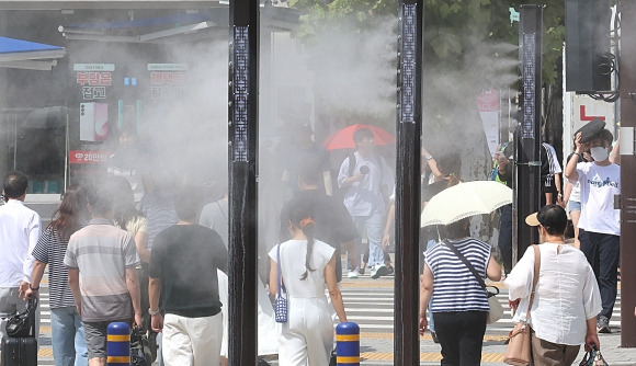 부산 폭염경보 무더운 추석 예상 - 부산에 폭염경보가 발효된 지난 13일 부산역 앞 횡단보도를 지나는 귀성객 등 시민들 사이로 쿨링포그가 가동되고 있다. 2024.9.13 연합뉴스