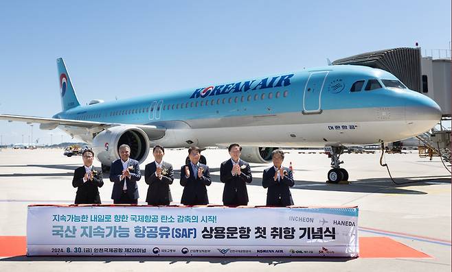 대한항공이 8월 30일 인천국제공항 제2터미널에서 국산 지속가능항공유(SAF)를 사용한 상용 운항 취항을 기념해 행사를 열고 있다. 왼쪽부터 오종훈 SK에너지 사장, 안와르 에이 알-히즈아지 에쓰오일 대표이사, 안덕근 산업통상자원부 장관, 박상우 국토교통부 장관, 우기홍 대한항공 대표이사 사장, 이학재 인천국제공항공사 사장. 대한항공 제공