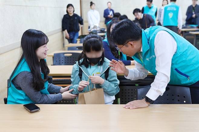 강성묵 하나증권 대표이사(오른쪽 첫번째)와 하나증권 임직원이 서울맹학교에서 봉사활동 하는 모습 하나증권 제공