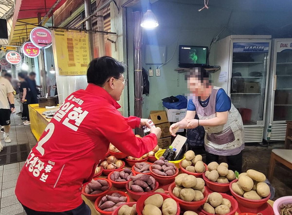 국민의힘 윤일현 후보가 금정구 한 전통시장에서 명함을 나눠주고 있다. 후보 제공