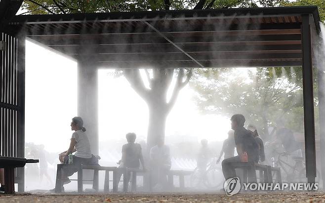 폭염 찾아온 서울…그늘에서 쉬는 시민들 (서울=연합뉴스) 김성민 기자 = 서울 서남권에 폭염 경보가 발효된 18일 오후 서울 영등포구 여의도공원에서 시민들이 더위를 피해 쿨링포그가 나오는 그늘에서 쉬고 있다.  2024.9.18 ksm7976@yna.co.kr