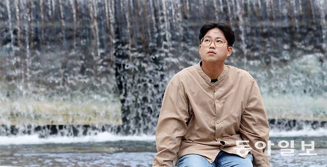 15일 서울 청계천 앞에 앉은 박준 시인. 박 시인은 “말을 당장 내 기분에 따라 쏟아내면 결국 누군가에게 가 박힐 것”이라며 “에둘러 말하거나 끝내 말하지 않고 오래 간직하는 방식이 한국 시의 특징이고 한국인의 정서”라고 말했다. 장승윤 기자 tomato99@donga.com