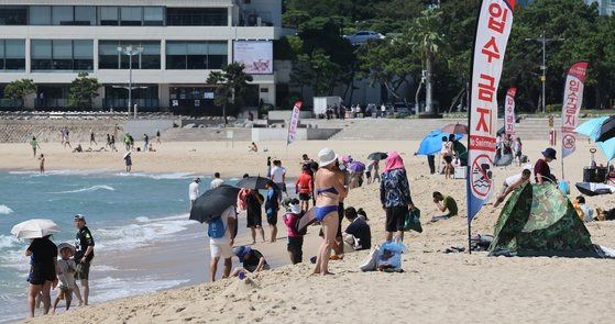 추석 연휴 마지막날인 지난 18일 늦더위가 기승을 부리자 부산 해운대해수욕장을 찾은 외국인과 시민이 바다에 뛰어들어 식히고 있다. 송봉근 기자