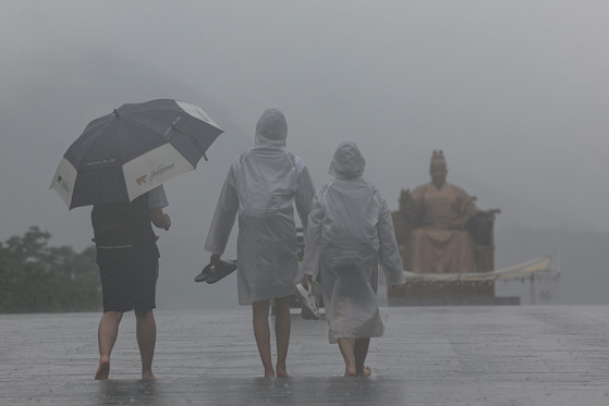 People walk in the monsoon rain in Gwanghwamun, central Seoul, on July 4, 2023 [YONHAP]