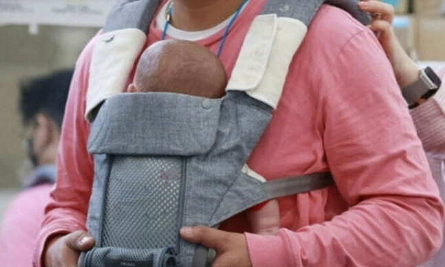 한 아버지가 아기띠로 신생아를 안고 있는 모습. 연합뉴스