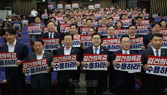 이재명 더불어민주당 대표와 박찬대 원내대표를 비롯한 의원들이 19일 국회에서 열린 의원총회에서 김건희 특검법 수용 촉구 손피켓을 들고 구호를 외치고 있다. 2024.9.19 홍윤기 기자