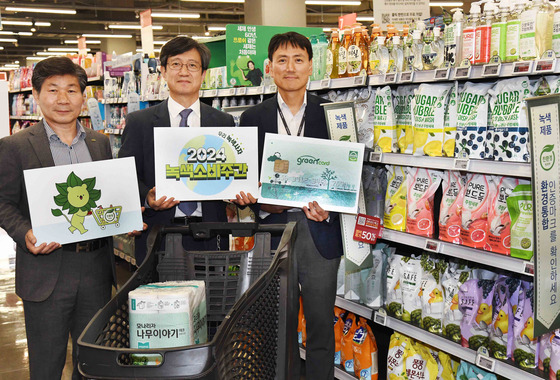 Government and industry representatives pose for a photo at a Homeplus supermarket to promote sustainable practices at an event organized by the Ministry of Environment. [HOMEPLUS]