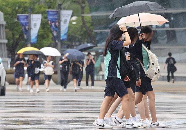 20일 오후 부산 해운대구 벡스코에서 ‘2024 창의융합 한마당’ 행사에 참여하는 학생들이 우산을 쓰고 이동하고 있다. 연합뉴스