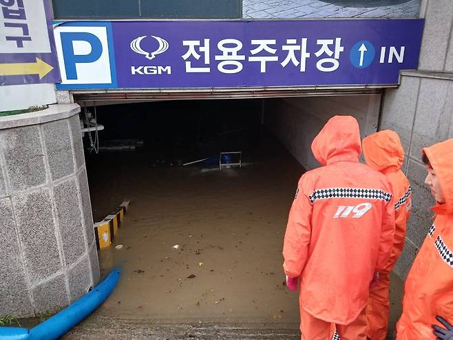 21일 오후 호우경보가 발효된 부산 연제구의 한 건물 지하주차장이 물에 잠겨 소방대원들이 배수 작업을 벌이고 있다. /뉴시스