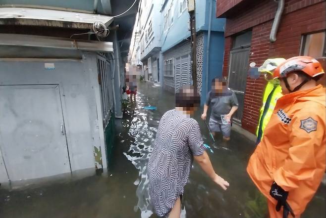 21일 오전 부산 부산진구 범천동 한 마을 골목이 폭우로 사람의 무릎 높이까지 물에 잠겨 있다. (부산소방제공) /연합뉴스