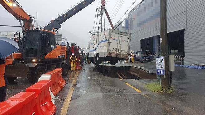 [부산=뉴시스] 권태완 기자 = 21일 오후 부산 사상구의 한 도로에서 발생한 땅꺼짐(싱크홀)에 빠졌던 소방배수지원차가 인양되고 있다. (사진=부산소방재난본부 제공) 2024.09.21. photo@newsis.com *재판매 및 DB 금지