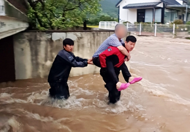 전남 여수 소라면에서 소방관들이 물에 잠긴 집에서 주민을 업고 나오는 모습. 전남소방본부 제공