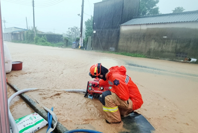 전남 해남군 황상면에서 소방관이 빗불에 잠긴 도로에서 물을 빼는 작업을 힘겹게 벌이고 있다. 전남소방본부 제공