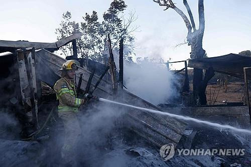 이스라엘 소방관이 헤즈볼라 로켓 공격으로 발생한 산불을 끄고 있다./ AFP=연합뉴스