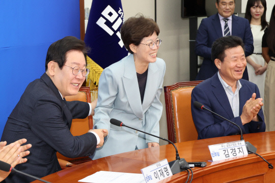 이재명 더불어민주당 대표가 11일 오전 국회에서 열린 10.16 재·보궐선거 공천장 수여식에서 소개를 마친 김경지 부산 금정구청장 보궐선거 후보와 악수하고 있다. 연합뉴스