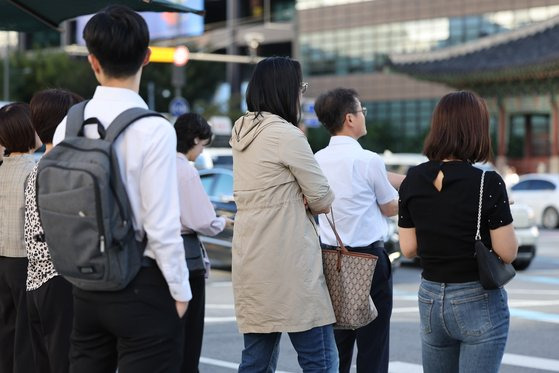 선선한 가을 날씨를 보인 23일 오전 서울 광화문네거리에서 트렌치코트를 걸친 시민이 횡단보도 신호를 기다리고 있다. 연합뉴스