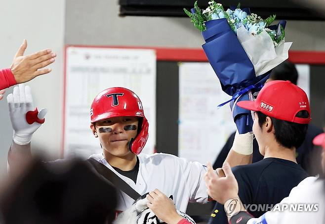 김도영, 홈런으로 시즌 최다득점 신기록 달성 (광주=연합뉴스) 조남수 기자 = 23일 광주기아챔피언스필드에서 열린 프로야구 삼성 라이온즈와 KIA 타이거즈의 경기에서 KIA 김도영이 1회말 선두타자로 나와 솔로홈런을 때리고 홈인한 뒤 꽃다발을 받고 동료와 하이파이브 하고 있다. 김도영은 이 홈런(시즌38호)으로 시즌 136득점째를 기록하며 단일 시즌 최다 득점 신기록을 달성했다. 2024.9.23 iso64@yna.co.kr