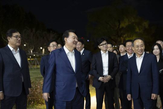 윤석열 대통령이 24일 서울 용산 대통령실 앞 분수정원에서 열린 국민의힘 지도부 초청 만찬 뒤 한동훈 대표, 추경호 원내대표 등 국민의힘 지도부, 대통령실 참모진과 함께 산책을 하고 있다.[대통령실 제공]