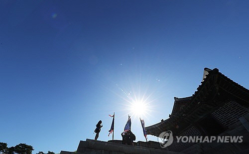 완연한 가을 날씨를 보인 24일 오전 경기도 수원시 세계문화유산 화성(華城) 창룡문을 찾은 학생들이 파란 가을 하늘을 배경으로 사진을 찍고 있다. [수원=연합뉴스]