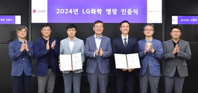 LG화학 명장으로 선발된 고영춘(왼쪽 세 번째) 전문과장, 성기욱(오른쪽 세 번째) 계장과 신학철(가운데) LG화학 부회장 등 임직원이 인증서를 전달하고 기념촬영을 하고 있다. LG화학 제공