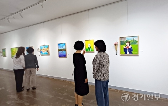 24일 수원시립만석전시관에서 개막한 ‘제8회 아그모 유화展’에서 관람객들이 작품을 살펴보고 있다. 정자연기자