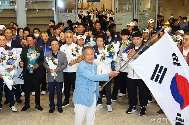 [인천공항=뉴시스] 황준선 기자 = 이기흥 대한체육회장이 8월13일 오후 2024 파리올림픽을 마친 뒤 인천국제공항을 통해 귀국하면서 예정됐던 유인촌 장관과 장미란 차관 등 문체부 주요 인사들도 참석하기로 돼 있던 공항 해단식을 일반적으로 취소하고 입국게이트 앞에서 기습적으로 약식 해단식을 대한체육회 독단으로 연 뒤 태극기를 휘두르고 있다. 공항 해단식은 대한체육회 주관행사로 장관과 차관이 초청 내빈으로 갔던 상황이었으나 대한체육회는 귀국 도중 짐을 찾는 면세구역 내에서 기습적으로 문체부 장관 등이 참석하게 돼 있는 공항 해단식 취소를 통보했다. 이에 해단식 취재를 위해 해단식 예정 장소에 와 있었던  취재진 일부는 입국 선수단을 놓치는 일고 발생했다. /2024.08.13. hwang@newsis.com /사진=황준선