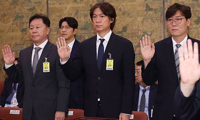 대한축구협회 정해성 전 전력강화위원장(왼쪽부터)과 축구 국가대표팀 홍명보 감독, 이임생 대한축구협회 기술총괄이사가 24일 국회에서 열린 문화체육관광위원회 전체회의에 출석, 증인 선서를 하고 있다. 연합뉴스