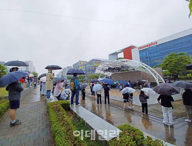 비가 내리는 5월5일 안산문화광장에서 열린 안산국제거리극축제에서 관객들이 우산을 쓰고 청학 팀의 로터리프로젝트 공연을 관람하고 있다. (사진 = 이종일 기자)