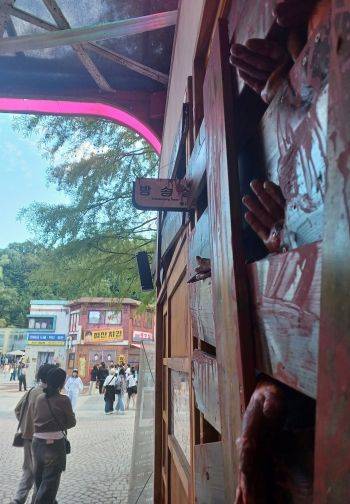 에버랜드 공포테마존 '블러드시티'에 구현된 넷플릭스 오리지널 드라마 '지금 우리 학교는(지우학)' 드라마 효산고 방송실을 관람객들이 24일 지나가고 있다.[사진=문채석 기자]