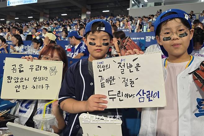 어린이집 동창으로서 인생의 절반인 6년을 함께 한 이동현(가운데), 유은준(오른쪽) 군은 각각 두산, 삼성 팬이다. 사촌 누나 김수빈(맨 왼쪽)과 함께 스케치북 문구 응원으로 추억을 쌓고 있다. 대구=윤승재 기자