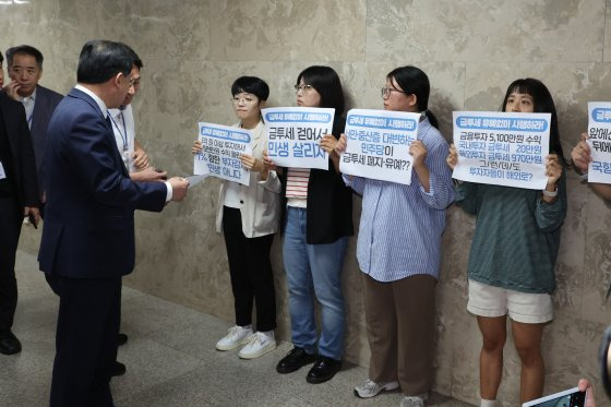 24일 오전 금융투자소득세(금투세) 관련 더불어민주당 정책 토론회가 열린 국회 회의실 앞에서 경실련·참여연대 회원들이 금투세 시행을 촉구하고 있다. [연합뉴스]