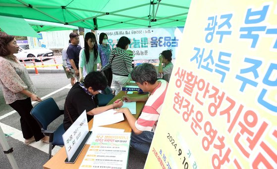 지난 11일 오전 광주 북구 두암3동 행정복지센터 앞 마당에서 북구 직원들과 복지도우미들이 생활안정지원금 지급 관련 업무를 하고 있다. 광주 북구 제공, 뉴스1