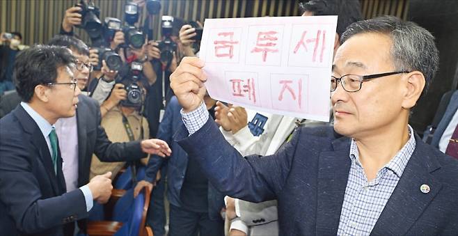 < 투자자들 “금투세 폐지” > 24일 국회에서 열린 더불어민주당의 금융투자소득세 토론회에 개인투자자들이 참석을 요구하며 민주당 의원들과 실랑이를 벌였다. 진성준 정책위 의장(왼쪽)이 막아서자 정의정 한국주식투자자연합회 대표(오른쪽)가 항의하고 있다.   강은구 기자