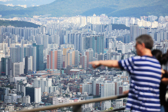 Onlookers view an apartment complex in Seoul from Mount Namsan on Wednesday. [YONHAP]