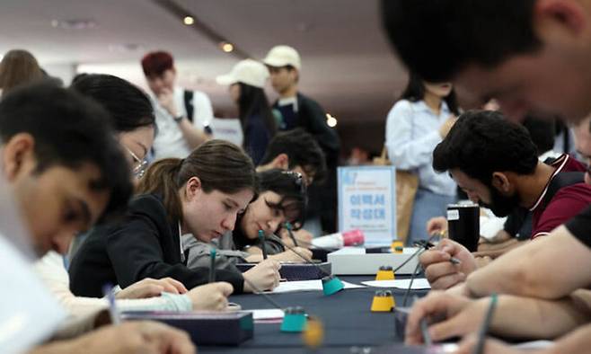 '지역특화형 비자 우수인재유형(F2R)과 연계한 외국인 유학생 채용박람회'가 열린 지난 5월 23일 오후 부산 해운대구 영화의전당 비프힐에서 외국인 유학생들이 이력서를 작성하고 있다. 뉴시스