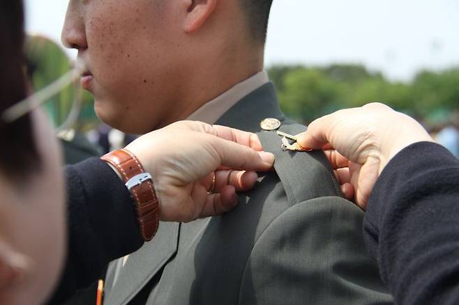 경북 포항 해병대 교육훈련단에서 열린 해병대 부사관 400기 임관식에서 한 후보생 부모가 아들에게 하사 계급장을 달아주고 있다(자료사진). ⓒ뉴시스