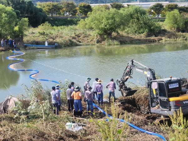 김해시 이동 주민이 26일 오전 이동 조만강에서 폭우로 떠내려간 간이상수도용 호스를 포크레인과 선박 등을 이용해 연결작업을 하고 있다. 박동필 기자