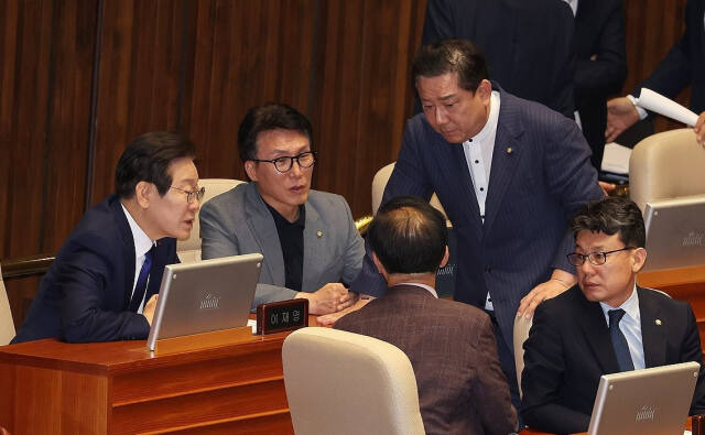 더불어민주당 이재명 대표가 26일 오후 국회에서 열린 본회의에서 동료 의원들과 대화하고 있다. 연합뉴스