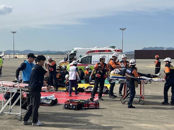 [서울=뉴시스] 26일 김해공항에서 이뤄진 재난대응 안전한국훈련 시범훈련 과정에서 자체소방대 초동 대응 및 응급환자를 이송하는 모습. 2024.09.26. (사진=한국공항공사 제공) photo@newsis.com  *재판매 및 DB 금지