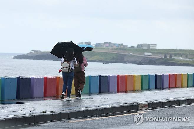 비 내리는 제주 (제주=연합뉴스) 박지호 기자 = 25일 오전 제주시 도두동 무지개해안도로를 찾은 관광객들이 바닷가 정취를 즐기고 있다. 2024.9.25 jihopark@yna.co.kr