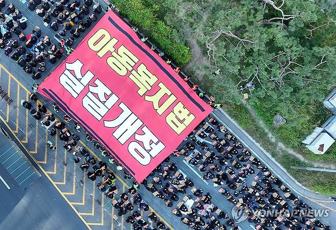 "아동복지법 제대로 개정하라" 2023년 10월28일 오후 서울 여의도 국회 앞에서 교사들이 아동복지법의 실질적 개정을 촉구하면서 대형 현수막을 옮기는 퍼포먼스를 하고 있다. [연합뉴스 사진]