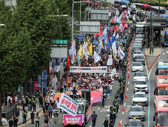 Protesters calling for President Yoon Suk Yeol's resignation march along a street near Seoul Station Saturday. (Yonhap)