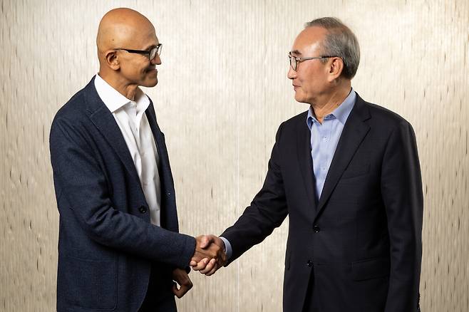 KT CEO Kim Young-shub, right, shakes hands with Microsoft CEO Satya Nadella after signing an agreement to collaborate in developing Korea-customized AI at the tech giant's headquarters in Redmond, Washington, on Friday. [KT]