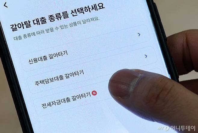 '전세대출 갈아타기' 서비스가 본격 시작된 31일 한 시민이 모바일 앱을 이용해 전세대출 갈아타기 서비스를 이용하고 있다.   전세대출은 대출 받은지 3개월이 지나야 갈아타기가 가능하다. 18개 은행과 3개 보험사 등 21개 금융사에서 받은 기존 전·월세 보증금 대출을 14개 은행의 신규 전·월세 보증금 대출로 임대인의 동의 없이 갈아탈 수 있다. 네이버페이, 카카오페이, 토스, 핀다 등 4개 핀테크사 앱과 14개 은행 앱을 통해서 갈아탈 수 있다./ 사진=뉴스1